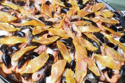 Miniature Traiteur Limas (Rhône) - Marc et Sophie Traiteur Cuisine & Services #33 Tour de choux décorée avec des fleurs et des étincelles, entourée de desserts sur une table de réception.
