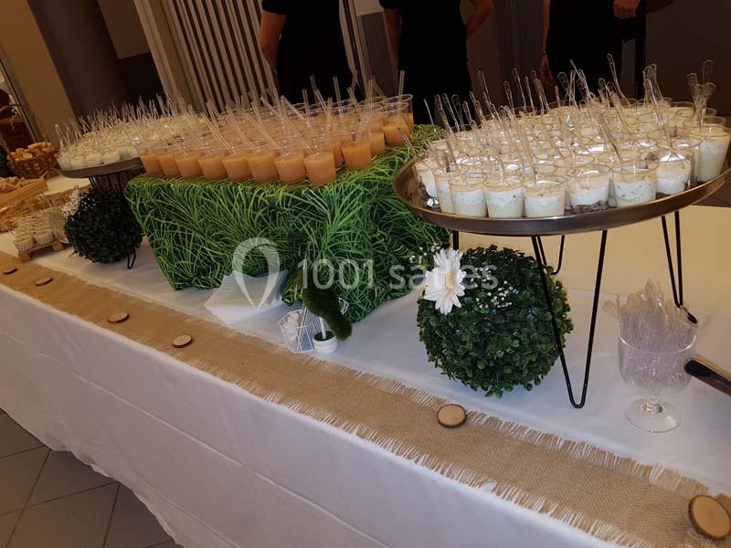 Table de buffet décorée avec des verrines salées et sucrées, entourées de décorations végétales et naturelles.