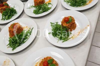 Tour de choux décorée avec des fleurs et des étincelles, entourée de desserts sur une table de réception.