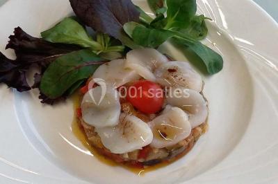 Tour de choux décorée avec des fleurs et des étincelles, entourée de desserts sur une table de réception.