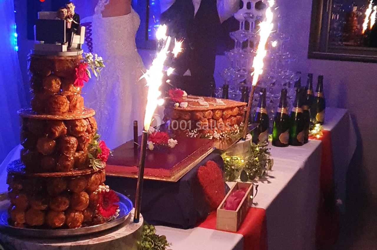 Table décorée pour un mariage avec pièce montée, fontaine de champagne et bougies scintillantes.