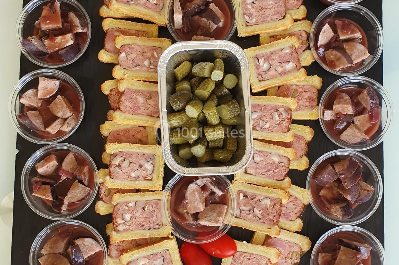 Plateau de charcuterie avec pâtés en croûte, cornichons, chorizo, tomates cerises et verrines de gelée de viande.