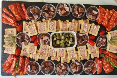 Tour de choux décorée avec des fleurs et des étincelles, entourée de desserts sur une table de réception.