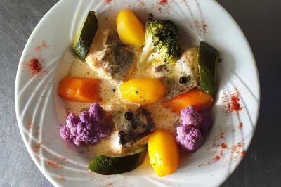 Tour de choux décorée avec des fleurs et des étincelles, entourée de desserts sur une table de réception.