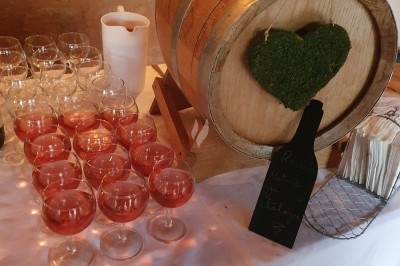 Buffet d'anniversaire en extérieur avec nappes blanches, plats variés, boissons et décor champêtre.