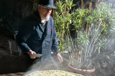 Buffet d'anniversaire en extérieur avec nappes blanches, plats variés, boissons et décor champêtre.