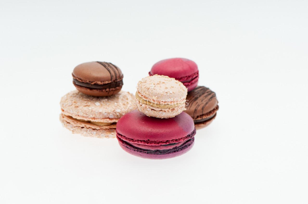 Assortiment de macarons colorés disposés sur une surface blanche.