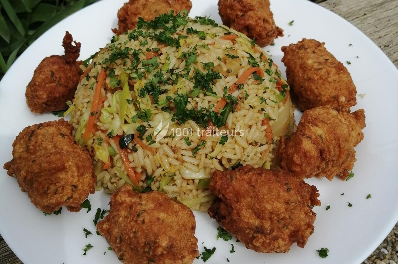 Assiette de riz sauté aux légumes garnie de beignets dorés et parsemée de persil haché.