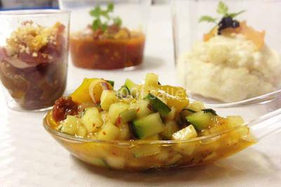 Plateau à étages avec des coquilles garnies de crevettes, légumes et herbes, présenté sur une table de buffet.