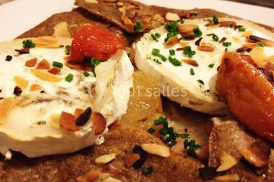 Plateau à étages avec des coquilles garnies de crevettes, légumes et herbes, présenté sur une table de buffet.
