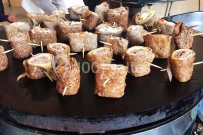 Plateau à étages avec des coquilles garnies de crevettes, légumes et herbes, présenté sur une table de buffet.