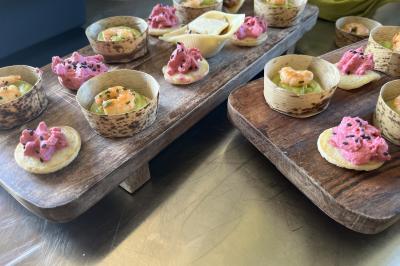 Plateau à étages avec des coquilles garnies de crevettes, légumes et herbes, présenté sur une table de buffet.