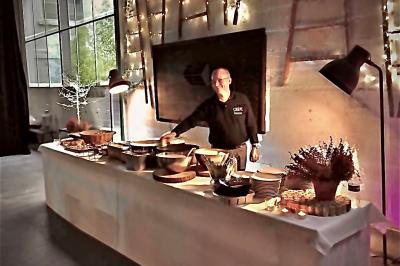 Plateau à étages avec des coquilles garnies de crevettes, légumes et herbes, présenté sur une table de buffet.