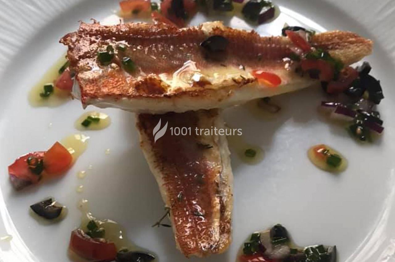 Filets de poisson grillés servis avec une garniture de légumes colorés et une sauce légère sur une assiette blanche.