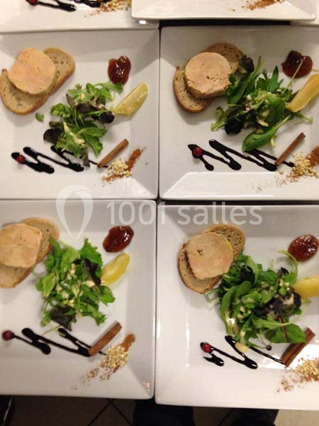 Assiettes dressées avec foie gras sur pain, salade verte, condiments, sauce balsamique et décorations culinaires.