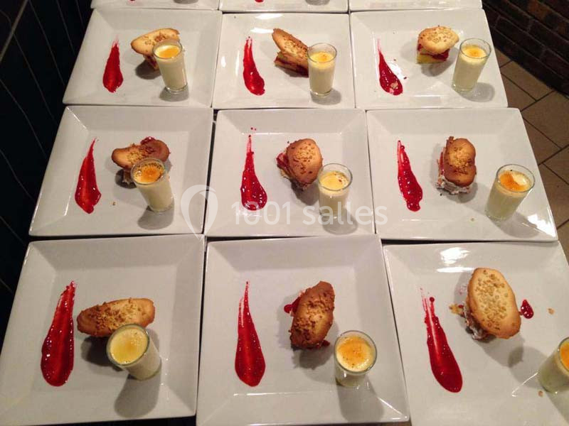 Assiettes dressées avec un dessert composé d'une verrine, d'un biscuit et d'un coulis rouge disposé en trait.
