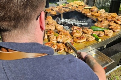 Plateau de mini-burgers, bouchées variées et garnitures sur une ardoise noire, présenté sur une nappe sombre.