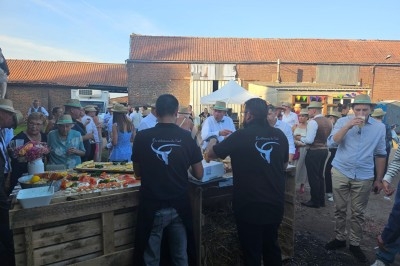 Plateau de mini-burgers, bouchées variées et garnitures sur une ardoise noire, présenté sur une nappe sombre.