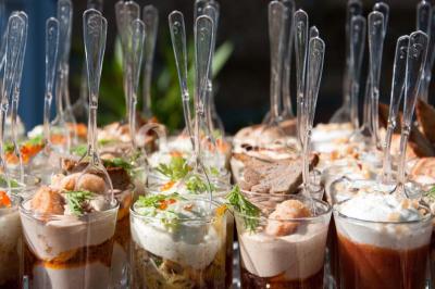 Buffet varié avec verrines, amuse-bouches, pains et pâtisseries disposés sur une table noire.