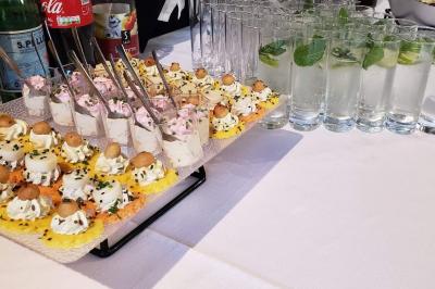 Buffet varié avec verrines, amuse-bouches, pains et pâtisseries disposés sur une table noire.