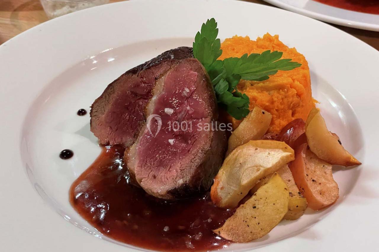 Assiette contenant un filet de viande saignante, purée de patate douce, pommes rôties et sauce au vin rouge.