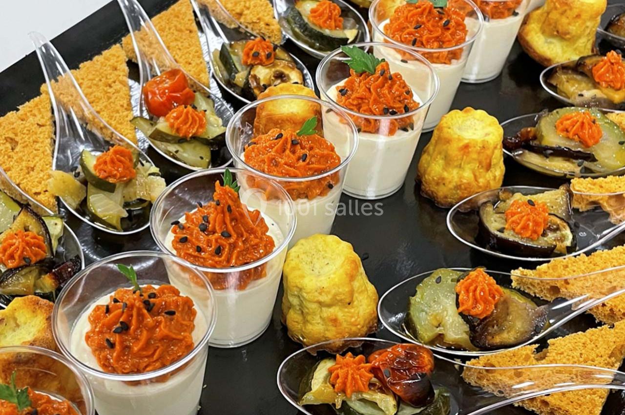 Plateau de bouchées apéritives variées avec verrines, cuillères garnies de légumes et petits cakes salés.