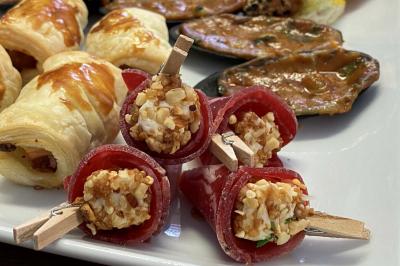 Table décorée pour un repas festif avec nappes blanches, verres, bougies, décorations végétales et petits cadeaux.