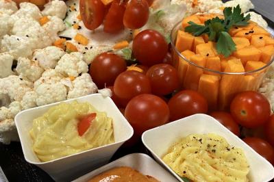 Table décorée pour un repas festif avec nappes blanches, verres, bougies, décorations végétales et petits cadeaux.