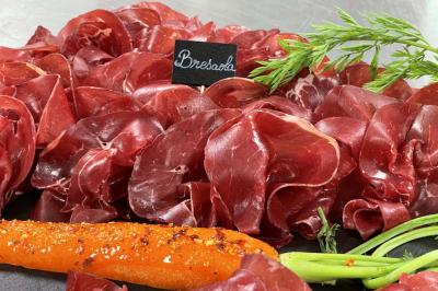 Table décorée pour un repas festif avec nappes blanches, verres, bougies, décorations végétales et petits cadeaux.