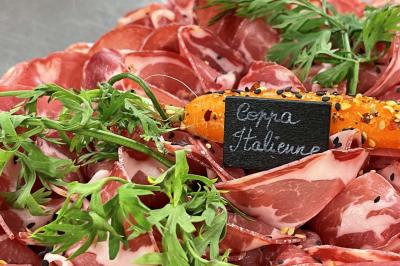Table décorée pour un repas festif avec nappes blanches, verres, bougies, décorations végétales et petits cadeaux.