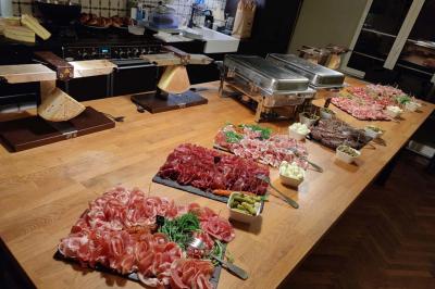 Table décorée pour un repas festif avec nappes blanches, verres, bougies, décorations végétales et petits cadeaux.