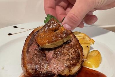 Table décorée pour un repas festif avec nappes blanches, verres, bougies, décorations végétales et petits cadeaux.