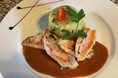 Table décorée pour un repas festif avec nappes blanches, verres, bougies, décorations végétales et petits cadeaux.