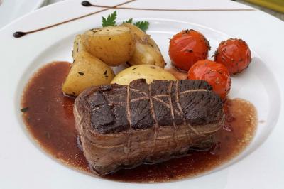 Table décorée pour un repas festif avec nappes blanches, verres, bougies, décorations végétales et petits cadeaux.