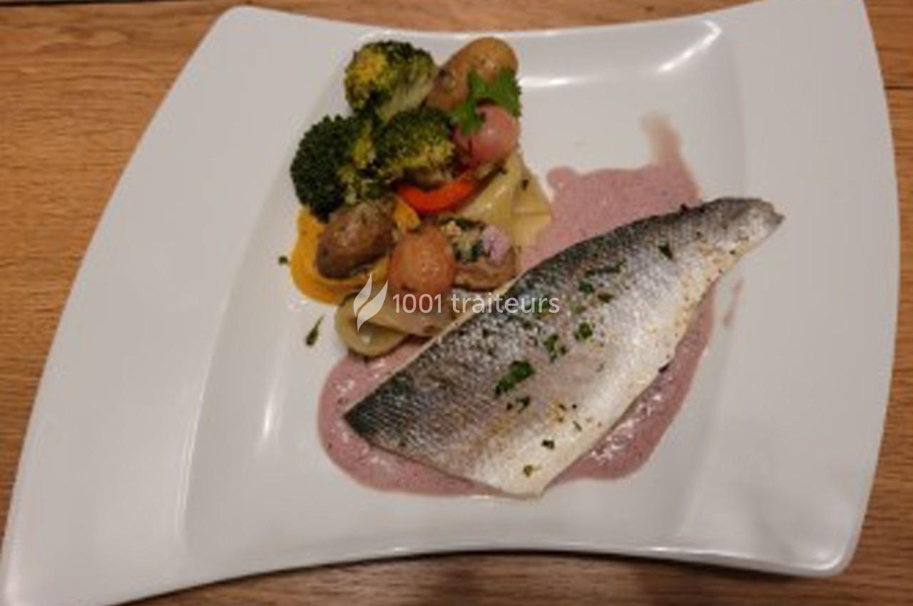 Filet de poisson servi avec légumes variés, tagliatelles et sauce rose sur une assiette blanche.