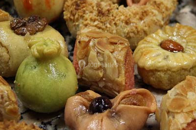 Miniature Traiteur Saint-Cyr-en-Val (Loiret) - Royal Events Traiteur et Tradition #2 Un homme en tenue traditionnelle sert du thé près d'une table garnie de pâtisseries et de verres dans une salle lumineuse.