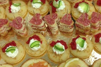 Miniature Traiteur Saint-Cyr-en-Val (Loiret) - Royal Events Traiteur et Tradition #5 Un homme en tenue traditionnelle sert du thé près d'une table garnie de pâtisseries et de verres dans une salle lumineuse.