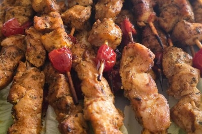 Miniature Traiteur Saint-Cyr-en-Val (Loiret) - Royal Events Traiteur et Tradition #11 Un homme en tenue traditionnelle sert du thé près d'une table garnie de pâtisseries et de verres dans une salle lumineuse.