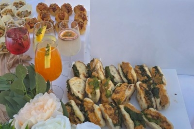 Miniature Traiteur Saint-Cyr-en-Val (Loiret) - Royal Events Traiteur et Tradition #13 Un homme en tenue traditionnelle sert du thé près d'une table garnie de pâtisseries et de verres dans une salle lumineuse.