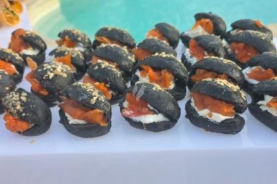 Miniature Traiteur Saint-Cyr-en-Val (Loiret) - Royal Events Traiteur et Tradition #14 Un homme en tenue traditionnelle sert du thé près d'une table garnie de pâtisseries et de verres dans une salle lumineuse.