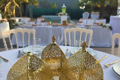 Miniature Traiteur Saint-Cyr-en-Val (Loiret) - Royal Events Traiteur et Tradition #20 Un homme en tenue traditionnelle sert du thé près d'une table garnie de pâtisseries et de verres dans une salle lumineuse.