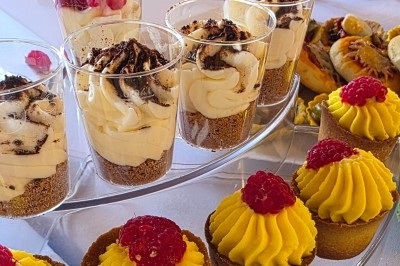 Miniature Traiteur Saint-Cyr-en-Val (Loiret) - Royal Events Traiteur et Tradition #22 Un homme en tenue traditionnelle sert du thé près d'une table garnie de pâtisseries et de verres dans une salle lumineuse.