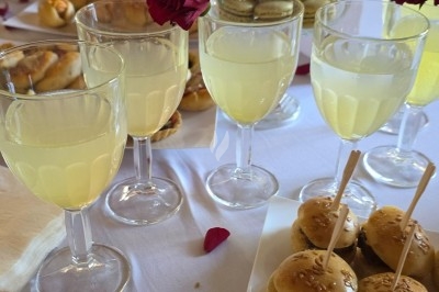 Miniature Traiteur Saint-Cyr-en-Val (Loiret) - Royal Events Traiteur et Tradition #23 Un homme en tenue traditionnelle sert du thé près d'une table garnie de pâtisseries et de verres dans une salle lumineuse.