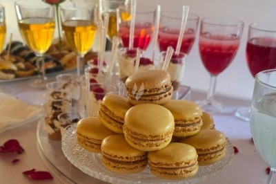 Miniature Traiteur Saint-Cyr-en-Val (Loiret) - Royal Events Traiteur et Tradition #26 Un homme en tenue traditionnelle sert du thé près d'une table garnie de pâtisseries et de verres dans une salle lumineuse.