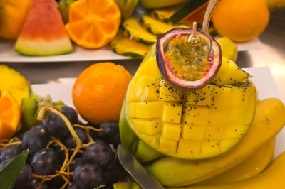 Miniature Traiteur Saint-Cyr-en-Val (Loiret) - Royal Events Traiteur et Tradition #27 Un homme en tenue traditionnelle sert du thé près d'une table garnie de pâtisseries et de verres dans une salle lumineuse.