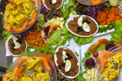 Miniature Traiteur Saint-Cyr-en-Val (Loiret) - Royal Events Traiteur et Tradition #29 Un homme en tenue traditionnelle sert du thé près d'une table garnie de pâtisseries et de verres dans une salle lumineuse.