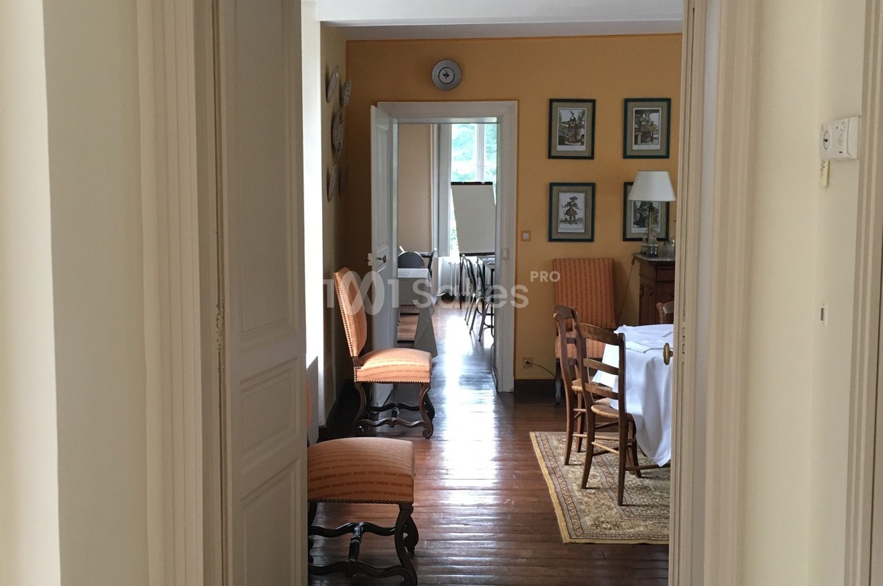 Vue d'un intérieur lumineux avec des murs jaunes, des meubles en bois et une table dressée dans une salle à manger.