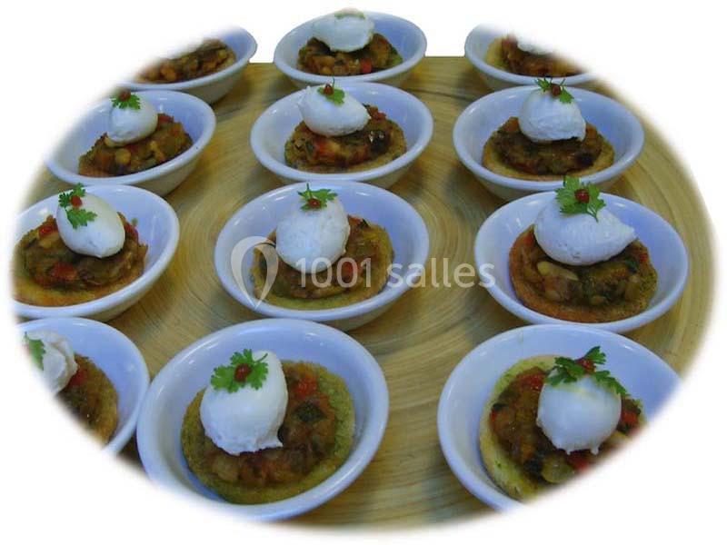 Petits plats individuels contenant une préparation de légumes garnie d'une boule de fromage et d'une feuille de persil.