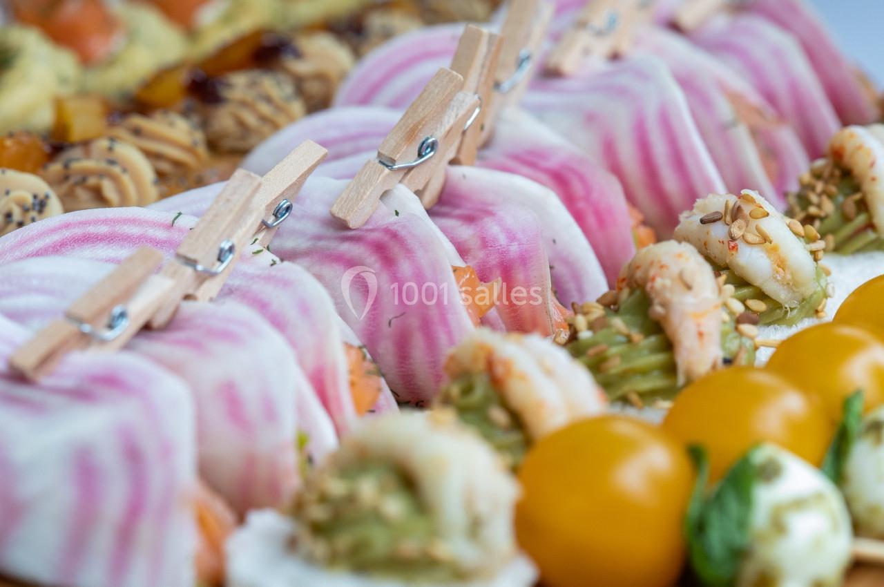 Assortiment de bouchées colorées avec légumes, crevettes, tomates cerises et décorations originales en pinces à linge.