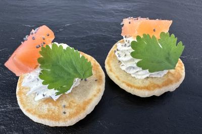 Miniature Blinis Cœur de Saumon Gâteau à trois étages décoré de motifs dorés, plumes blanches et perles, avec une inscription d'anniversaire.